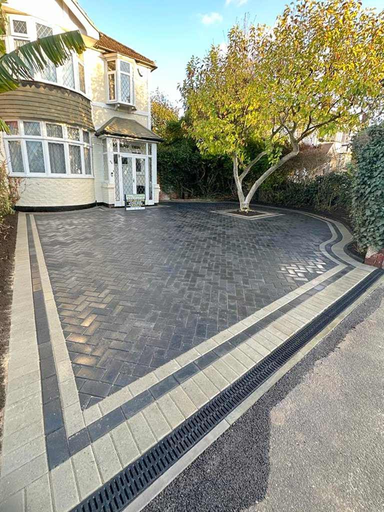Charcoal block paved driveway with contrasting light borders