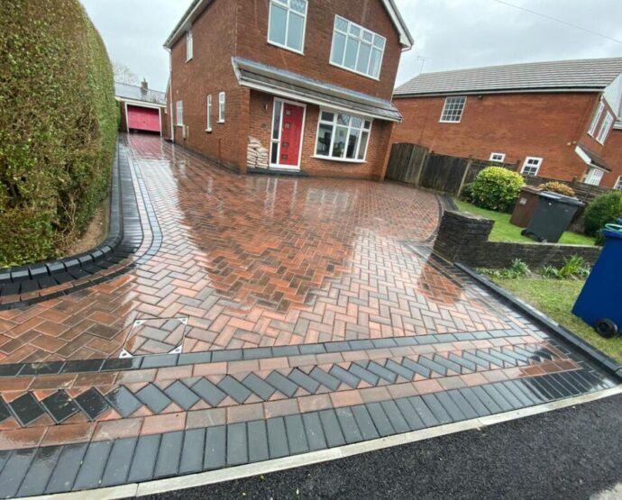 Wet-look multi-tone block paved driveway with a detailed entrance border